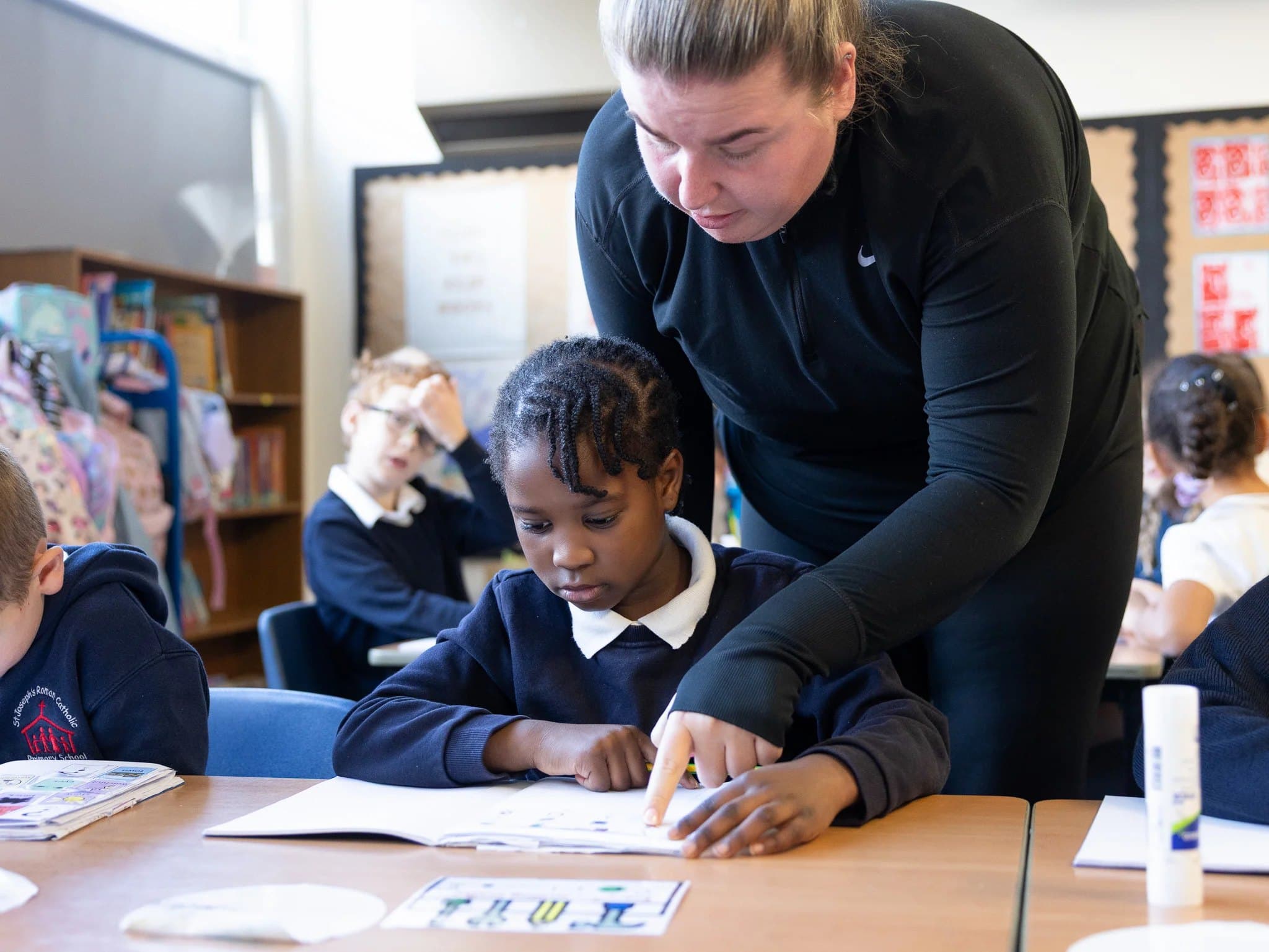 A teacher helping a pupil with her work