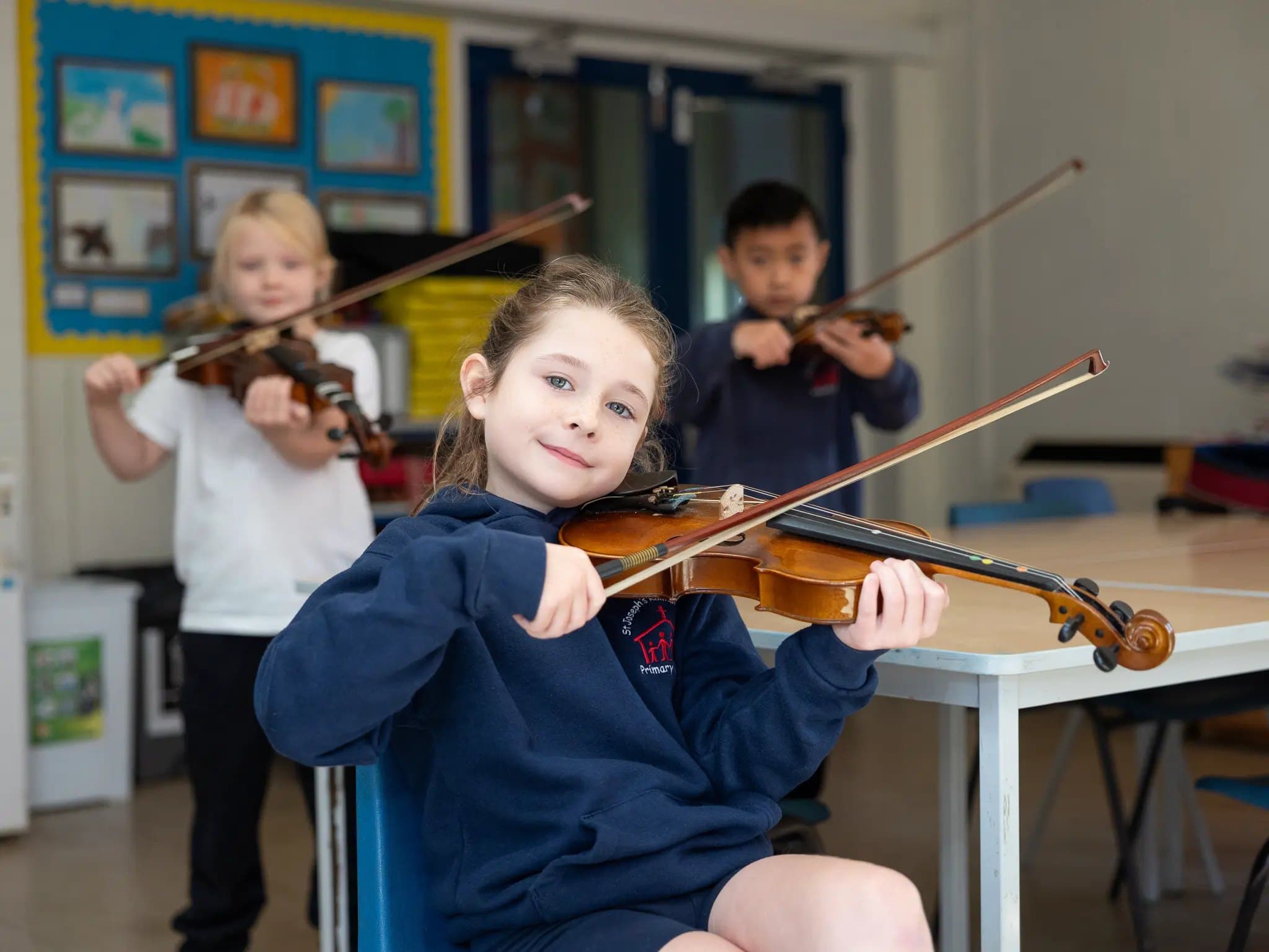 Pupils playing the violin in a music lesson
