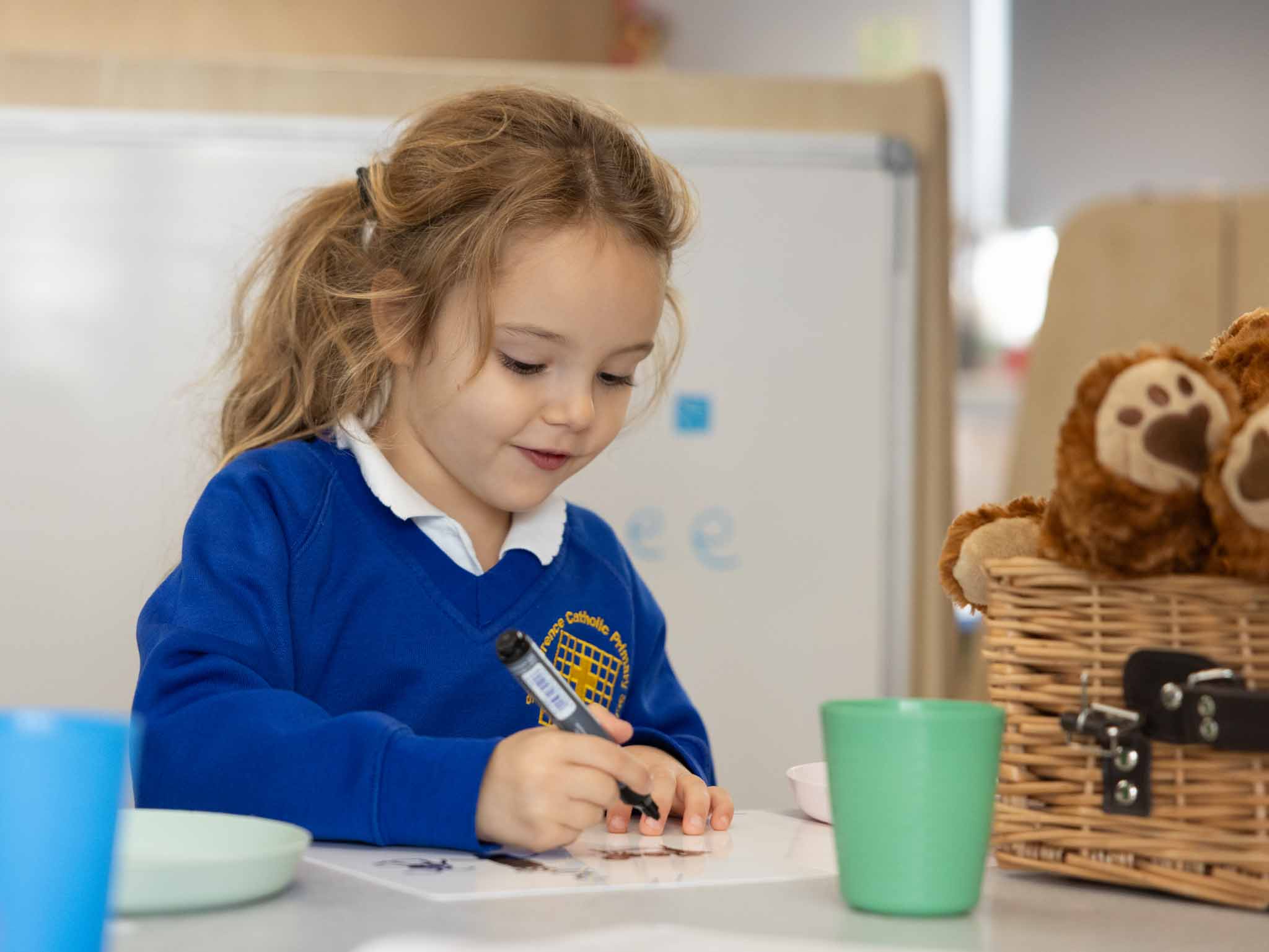 A young girl concentrating as she draws at her table