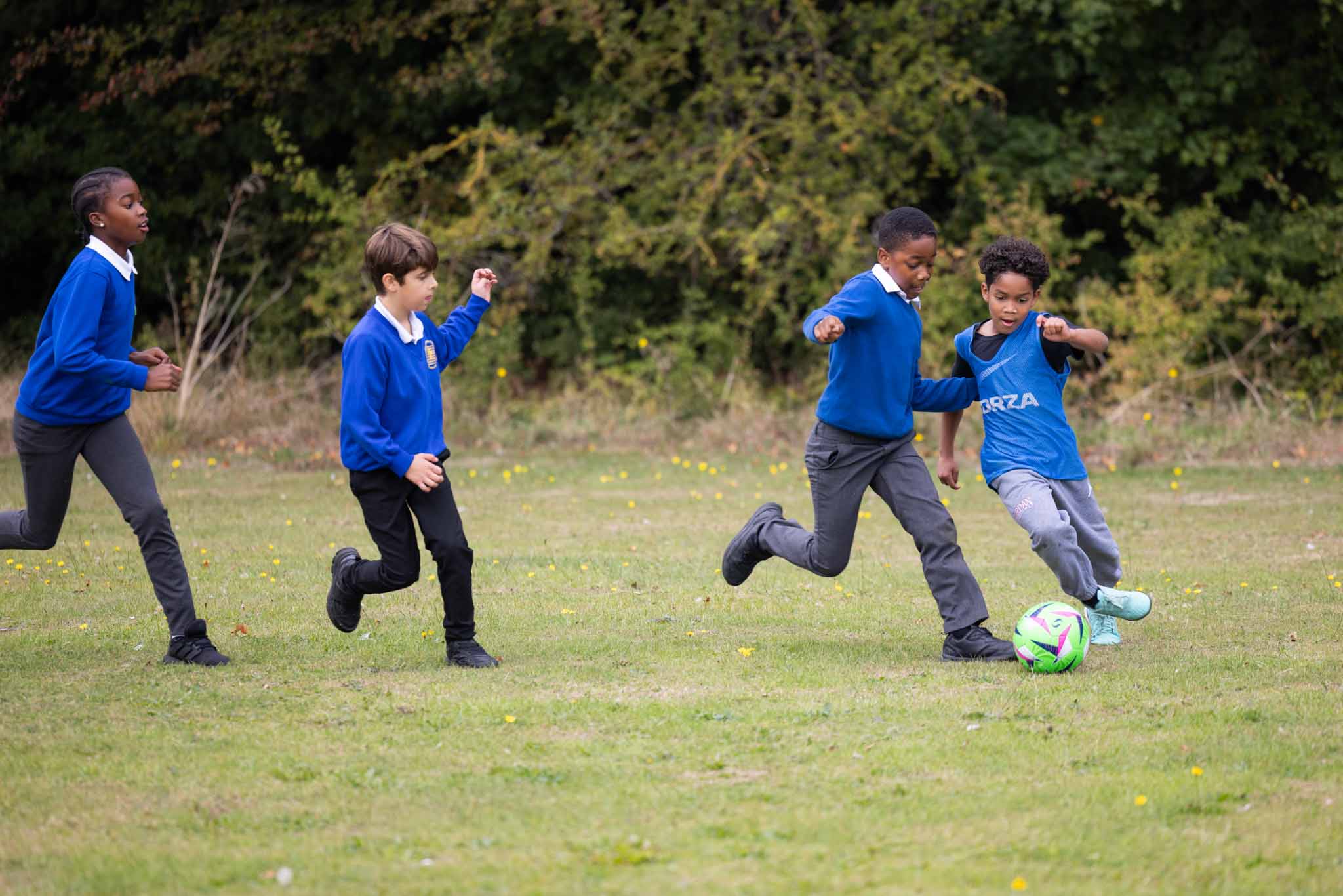 Pupils playing football on the school field