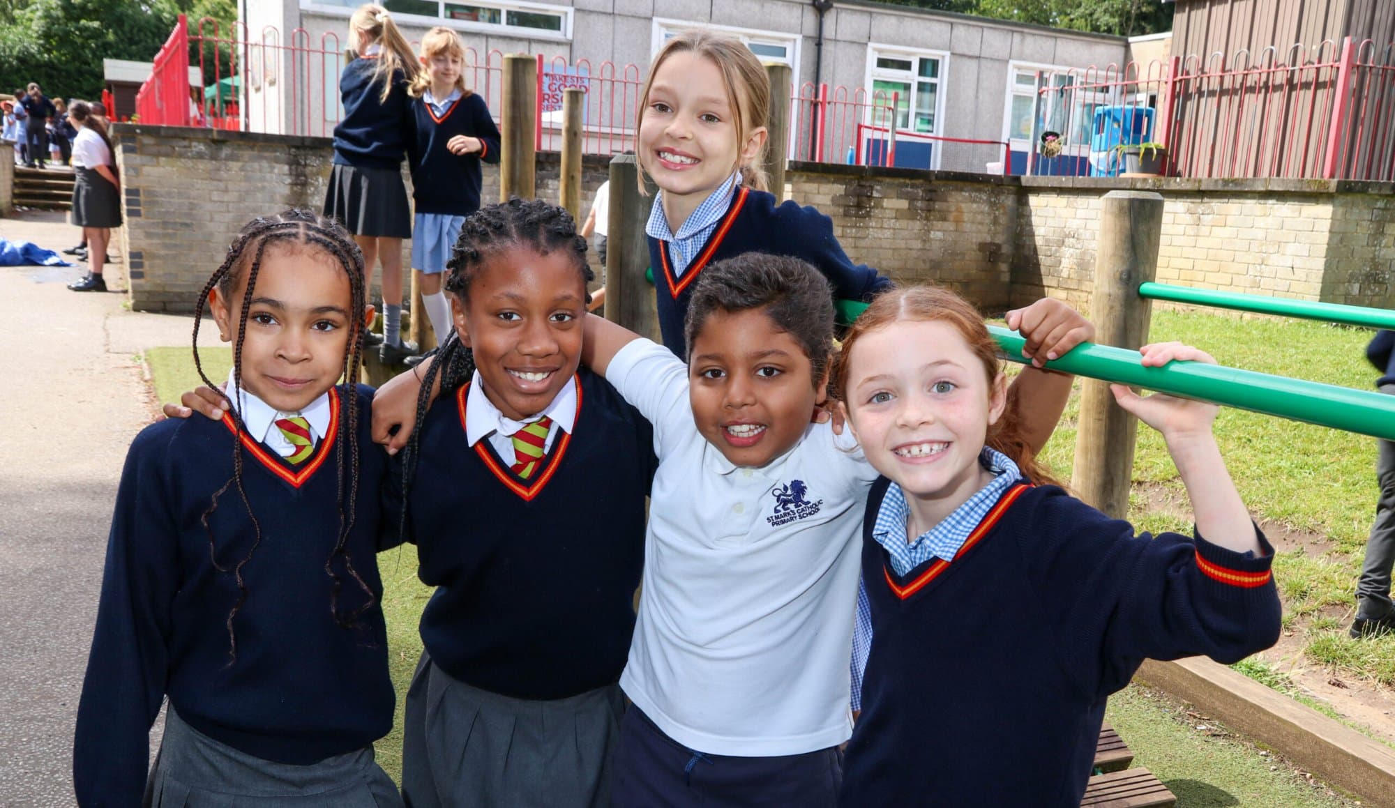 Group of smiling pupils in uniform on the playground