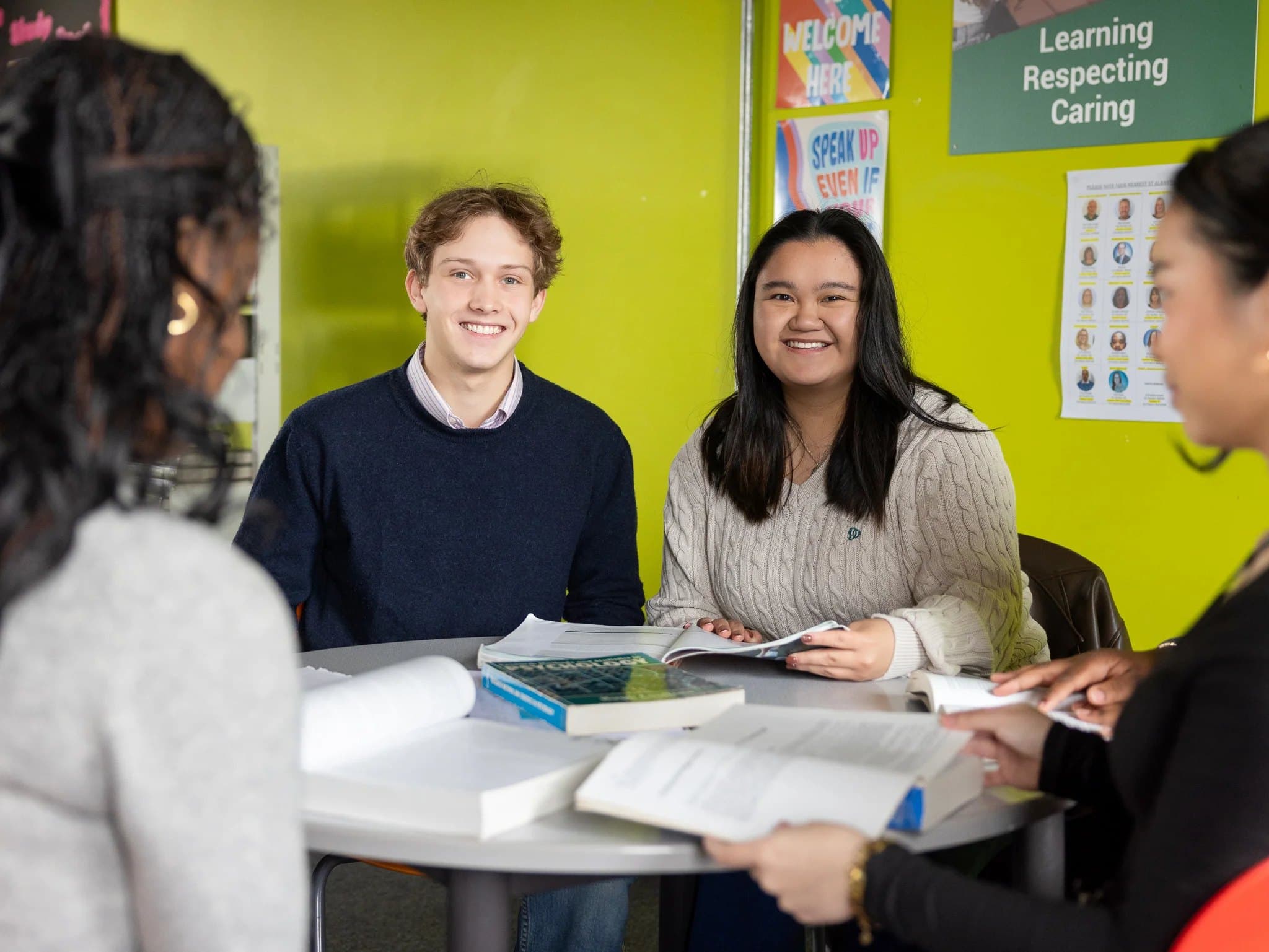 Two smiling sixth form students studying together at a round table