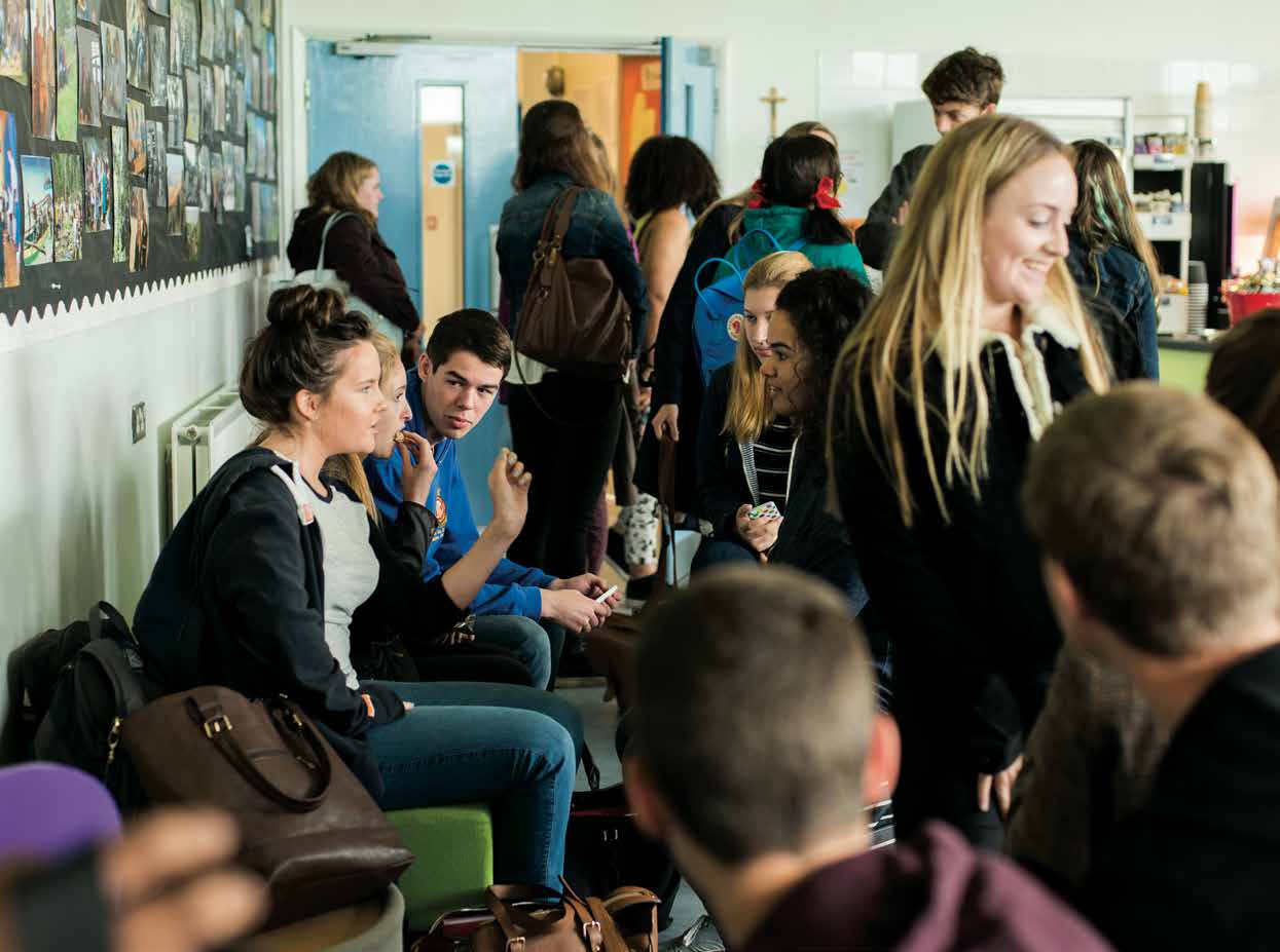 A busy sixth form common area with students chatting between lessons